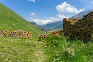 View of Truso valley from Zakagori fortress. Stone walls with orange lichen. Mountains around clipart