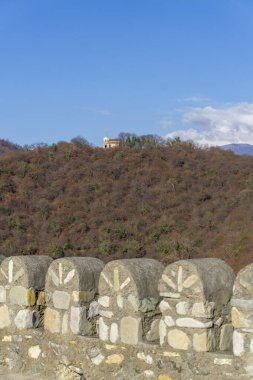 Small church on the hill. View from the tower of Tali fortress. Loopholes on the roof. clipart