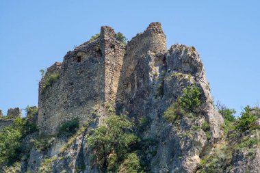 Büyük bir kayanın tepesindeki ortaçağ şatosunun kalıntıları. Taş duvarlar devam eder ve birleştirilir.