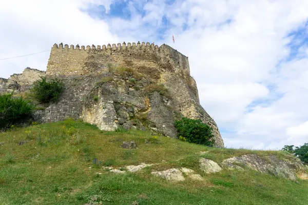 stock image Side view of Surami fortress built on a rock. Green grass, stone walls with loopholes