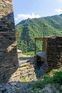 View of houses, balconies and mountains from the top of the street. Medieval village Mutso. clipart