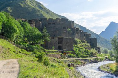 Nehir, toprak yol ve ortaçağ köyü Shatili. Arkaplanda dağlar