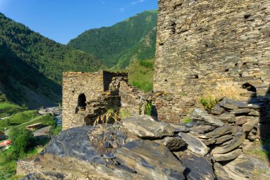 Ortaçağ Şatosu 'nun taş duvarları ve kuleleri. Arkaplanda dağlar.
