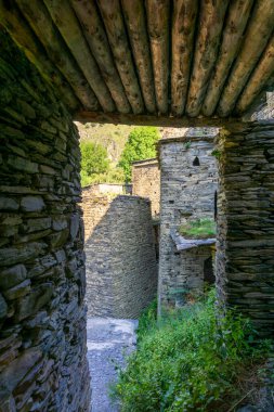 Taş kuleleri olan bir avluya çıkan ahşap tavanlı bir geçit. Ortaçağ köyü Shatili sokakları.