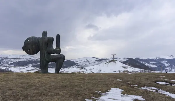 stock image Didgori battle memorial, Georgia. Winter and snow, overcast. Sculpture of a warrior with a sword and shield on the hill.