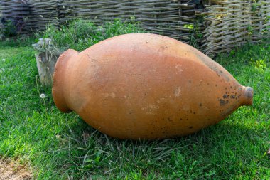 Çimlerin üzerindeki küçük Kvevri Qvevri Churi - Geleneksel Gürcistan şarabının mayalanması, depolanması ve yaşlanmasında kullanılan toprak kap.