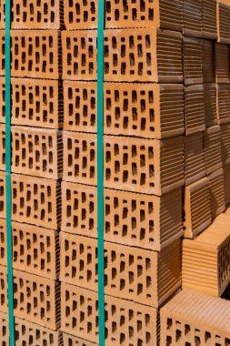 Yeşil kurdeleyle bağlanmış yeni turuncu tuğlalar. Yan görüş. Kaburgalı, dikdörtgen delikler