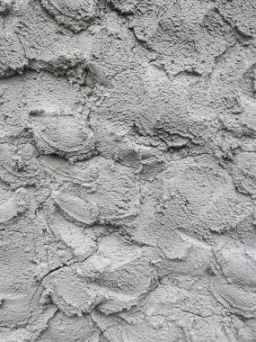 Duvardaki pürüzlü ve pürüzlü beton alçıyı kapat. Tümsekler ve damlalar görünür.