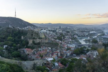 Tiflis, Georgia 'nın şehir manzarası. TV kulesi, Gürcistan 'ın Anası heykeli, Narikala kalesi, Mtkvari nehri (Kura) nehri, şehir merkezi, dağlar ve açık gökyüzü