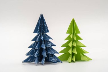 Süsleme için arigami gibi mavi ve yeşil kağıttan yapılmış iki noel ağacı.