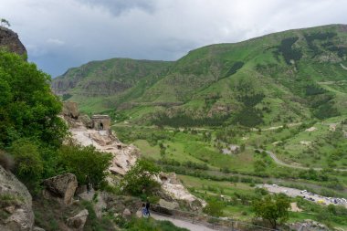 Dağdaki mağaraların, nehir vadisinin ve mavi gökyüzünün gündüz manzarası. Vardzia, Erusheti Dağı 'nda kazı yapılan bir mağara manastırı. Kafkas, Gürcistan