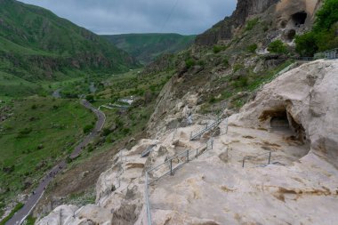 Mağaraların, merdivenlerin ve dağların gündüz manzarası. Vardzia bir mağara manastırı, eski bir kaya oyması.