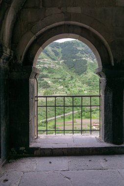 View of the mountain through the church arch and railings. Vardzia is a cave monastery, an ancient rock-hewn clipart