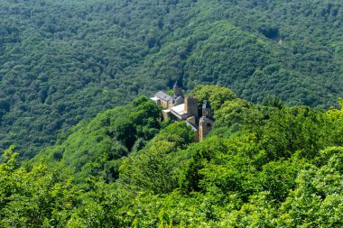 Etrafı ağaçlar ve dağlarla çevrili manastırın dağından bak. Çan kulesi, savunma kulesi ve kilise görünür durumda. Martkopi manastırı, Georgi.