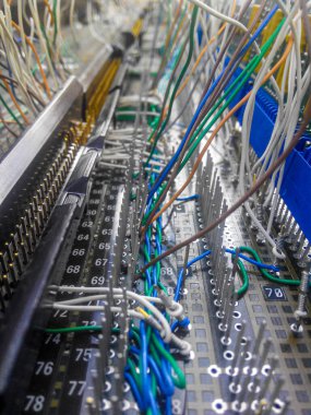 Elektronik devre detayları, bağlantıları ve renkli kabloları olan bir tahta. Numaralı bağlayıcılar. Kabloyu sökmek için iğneler. Bakış açısı