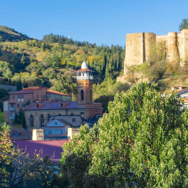 Tiflis 'teki Juma Camii, Narikala Kalesi' nin duvarı. Sıcak güneş ışığı, parlak gökyüzü.