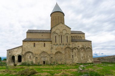 Alaetti Manastırı 'nın Aziz George Kilisesi' nin avlusunda. Yeşil alan, bulutlu gökyüzü