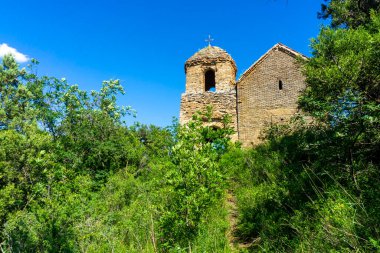 Tepedeki küçük kilise Shio-Mgvime manastırının bir parçasıdır. Arkadaki parlak mavi gökyüzü.