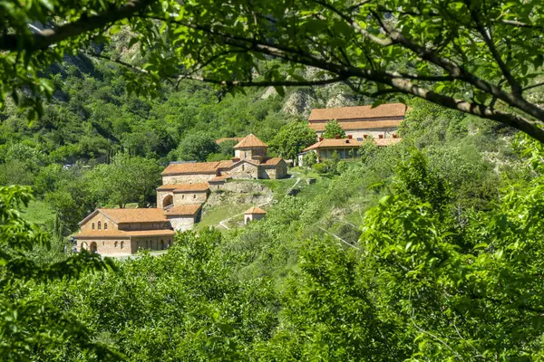 Dağdan ağaç yapraklarının arasından Shio-Mgvime manastırı kompleksine bak..