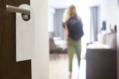 Kadın otel odasının kapısını açıyor.