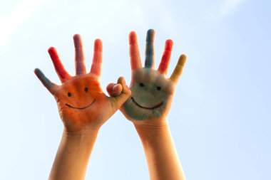 Mutlu çocuklar renkli bir gökyüzünde el boyadılar.