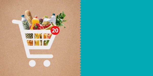 Online shopping app: shopping cart icon full of fresh groceries and copy space