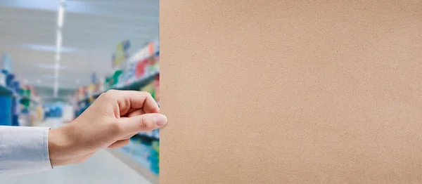 手握再生纸标牌和超市过道背景 食品杂货购物和商业概念 — 图库照片