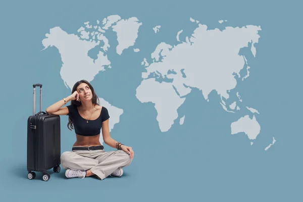 幸せな旅行者の女性は彼女の国際旅行を計画し 背景に世界地図 — ストック写真