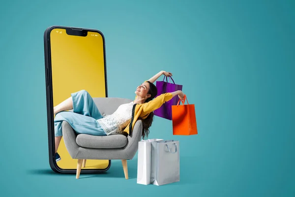 Glückliche Modische Junge Frau Sitzt Und Hält Einkaufstüten Einem Smartphone — Stockfoto