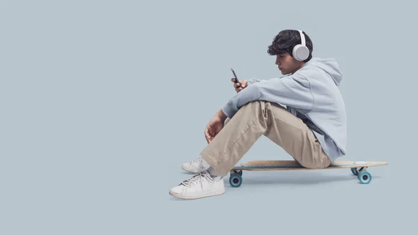 Skater Usando Fones Ouvido Sentado Seu Skate Ele Está Conectando — Fotografia de Stock