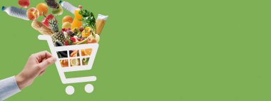 Elinde taze yiyecek dolu bir alışveriş arabası ikonu var: çevrimiçi market alışverişi ve teslimat uygulaması