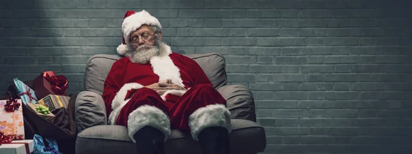 困了圣诞老人睡午觉和圣诞前夜在扶手椅上休息 — 图库照片