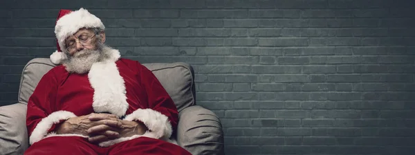 困了圣诞老人睡午觉和圣诞前夜在扶手椅上休息 — 图库照片