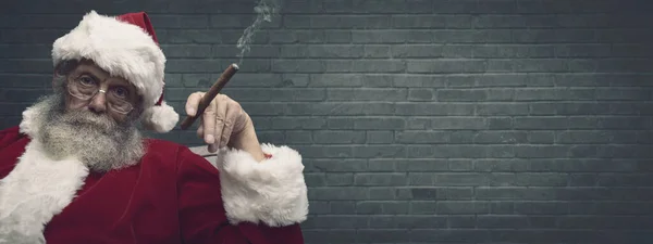 圣诞老人抽雪茄和庆祝圣诞节很糟糕 他盯着摄像机看 — 图库照片