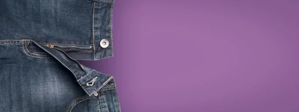 Denim blue jeans and purple background, open zipper