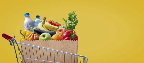 Supermarket shopping cart full of groceries, sale and retail concept, copy space