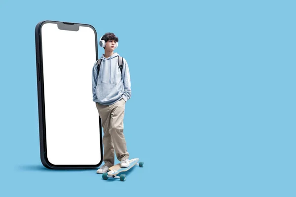 Tiener Skater Met Hoofdtelefoon Poseren Naast Een Grote Smartphone Met — Stockfoto