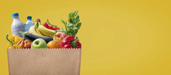 Paper grocery bag full of groceries: food and retail concept