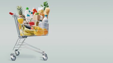 Taze yiyecek ve ev ürünleriyle dolu alışveriş arabası: market alışverişi kavramı