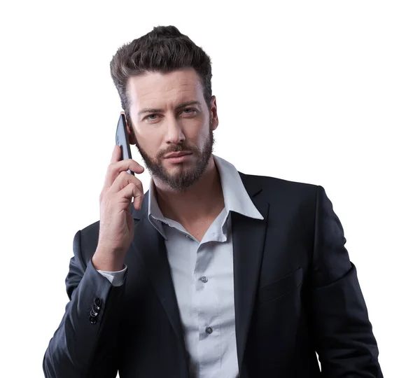 若い魅力的なビジネスマンは彼のスマートフォンで電話を持っています — ストック写真