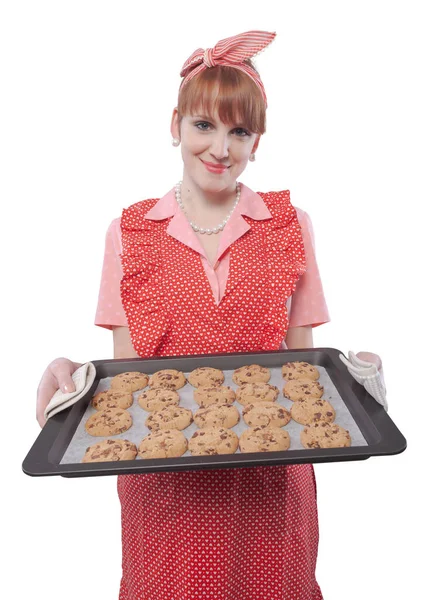 快乐而自信的老式风格家庭主妇拿着一个装有新鲜烘焙饼干的烤箱盘 — 图库照片