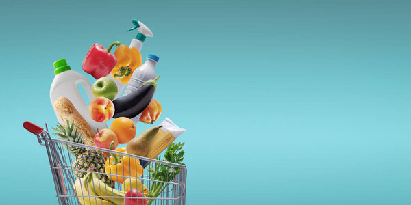 Fresh groceries and goods falling in a supermarket trolley, grocery shopping concept