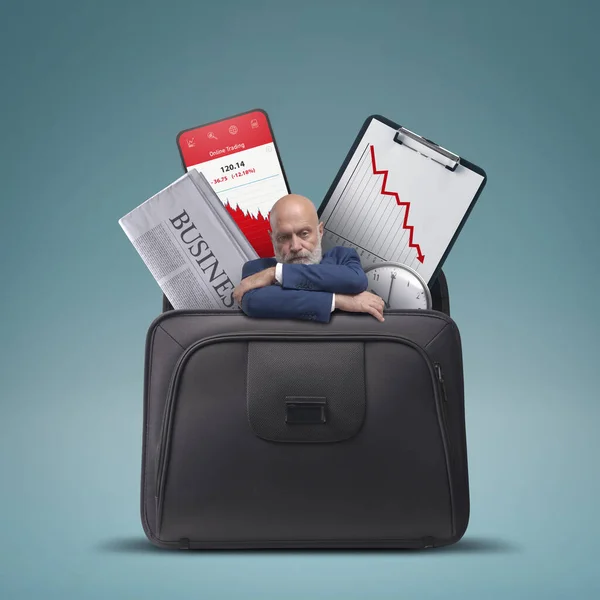 Stressed sad businessman and financial graphs showing loss in a briefcase, financial failure concept