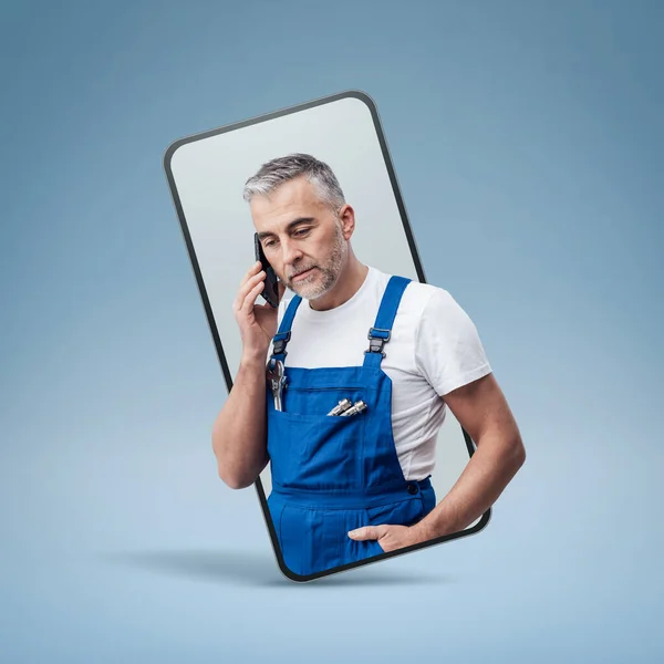Confident repairman and plumber having a phone call  in a smartphone , online  service concept