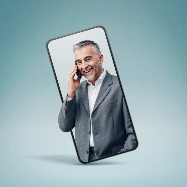スマートフォンのビデオコールと笑顔で電話を持っている自信を持って笑顔のビジネスマン オンラインサービスの概念 — ストック写真