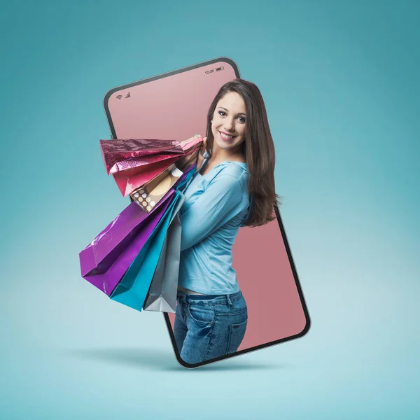 スマートフォンのビデオコールと笑顔でカラフルなバッグがたくさんある陽気な笑顔の女性のショッピング オンラインショッピングのコンセプト — ストック写真