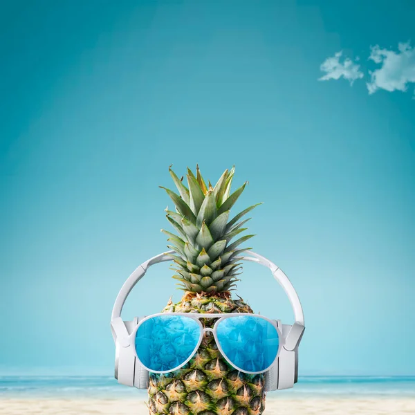 熱帯のビーチでヘッドフォンやサングラスを身に着けている面白いパイナップル 夏休みやパーティーのコンセプト コピースペース — ストック写真
