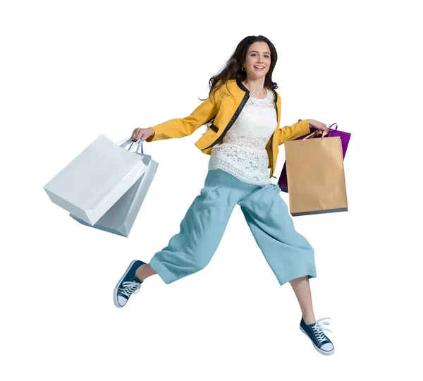 ショッピングを楽しむ陽気な幸せな女性 彼女はショッピングバッグを運び ショッピングセンターで最新のオファーを得るために実行しています — ストック写真