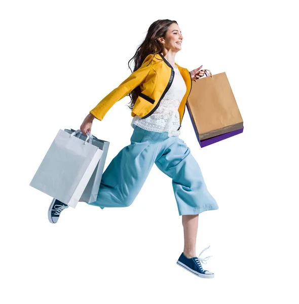 ショッピングを楽しむ陽気な幸せな女性 彼女はショッピングバッグを運び ショッピングセンターで最新のオファーを得るために実行しています — ストック写真