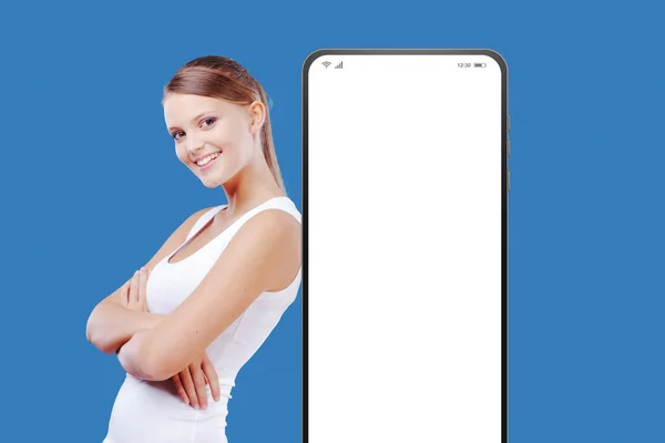 Lächelnde Junge Frau Lehnt Einem Großen Smartphone Mit Leerem Bildschirm — Stockfoto